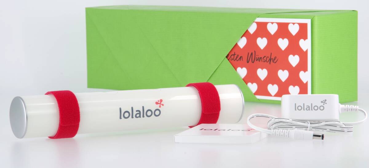 Lieferumfang: Baby Einschlafhilfe lolaloo als Geschenk verpackt, Glückwunschkarte mit persönlichem Grußtext, rote Klettbänder, Netzadapter und Bedienungsanleitung.