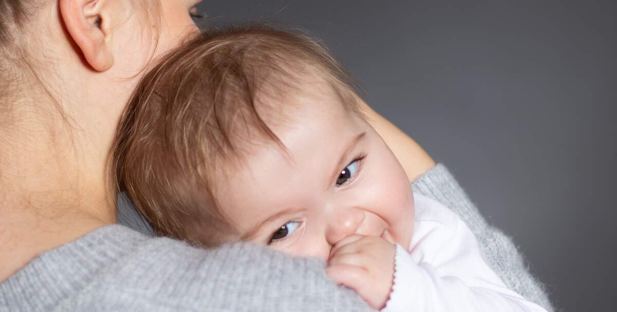 Ein Baby wird zur Beruhigung auf dem Arm geschaukelt.